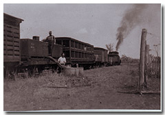 An early train pauses to fill a lineside water tank